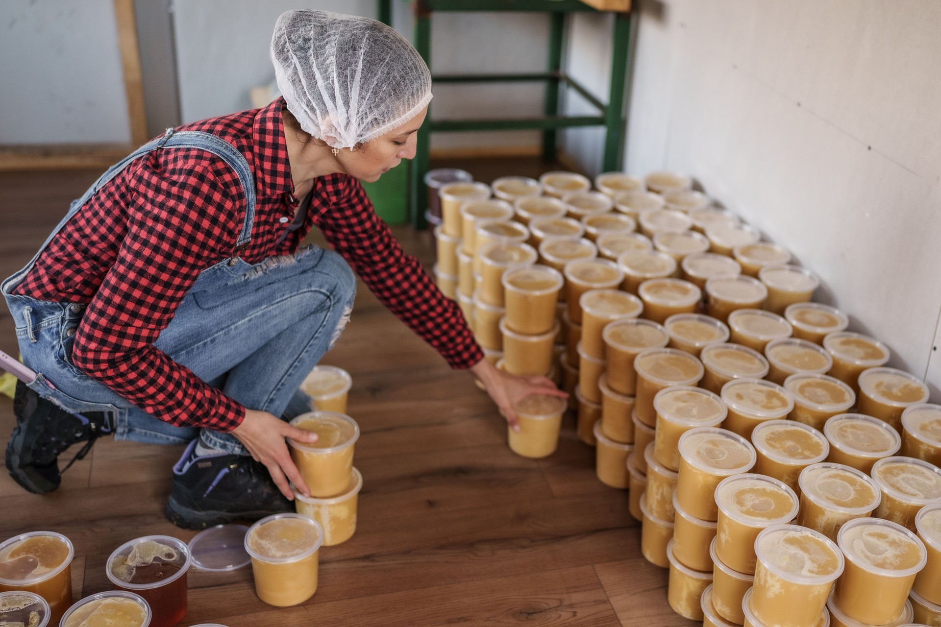 adult woman working stacking honey jars after harvest